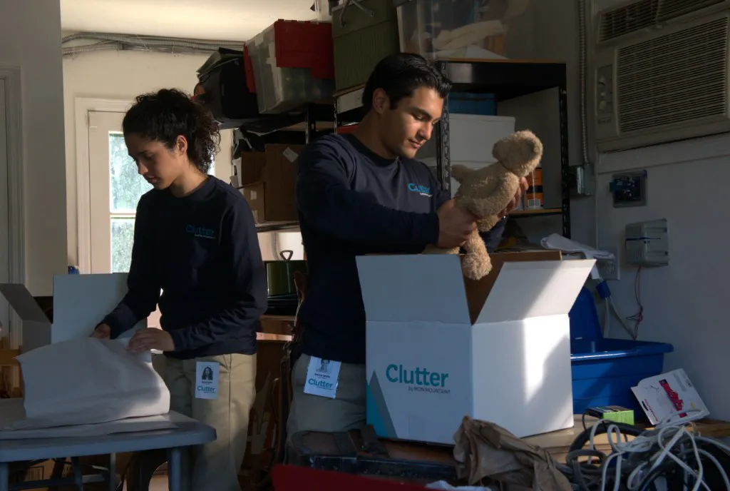 Clutter team packing items into branded boxes